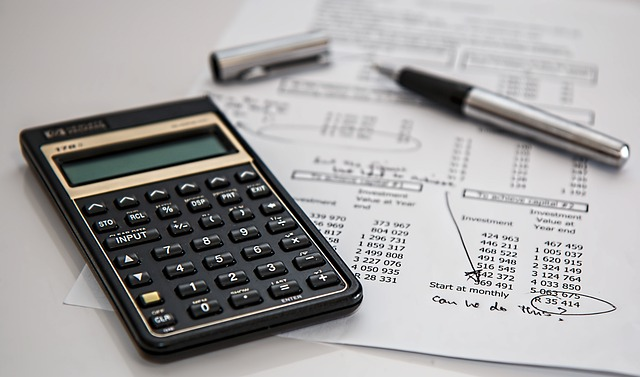 A calculator and a pen with a document 