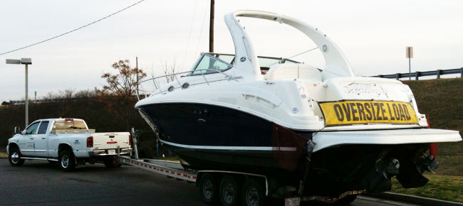 A boat being towed by a truck 