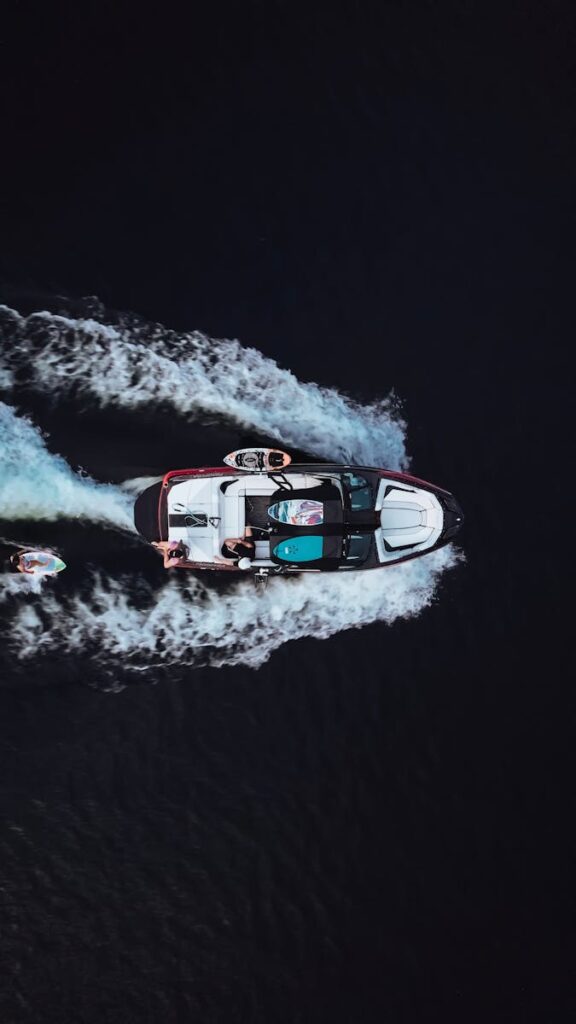 Aerial shot of motorboat creating waves on dark water, QC, Canada.