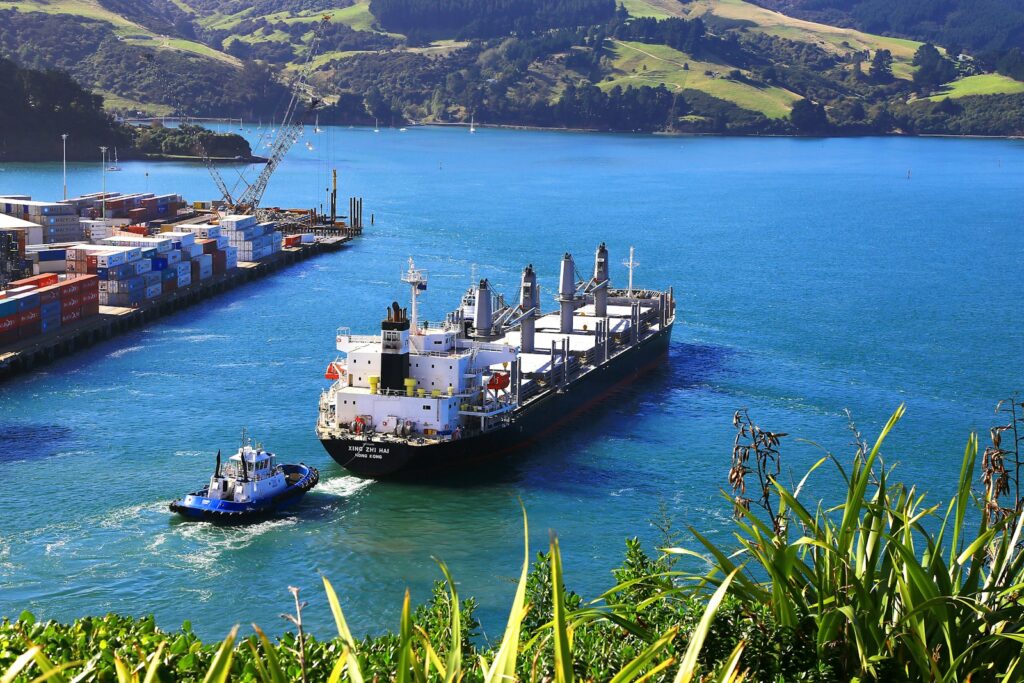 white cargo ship near thug boat