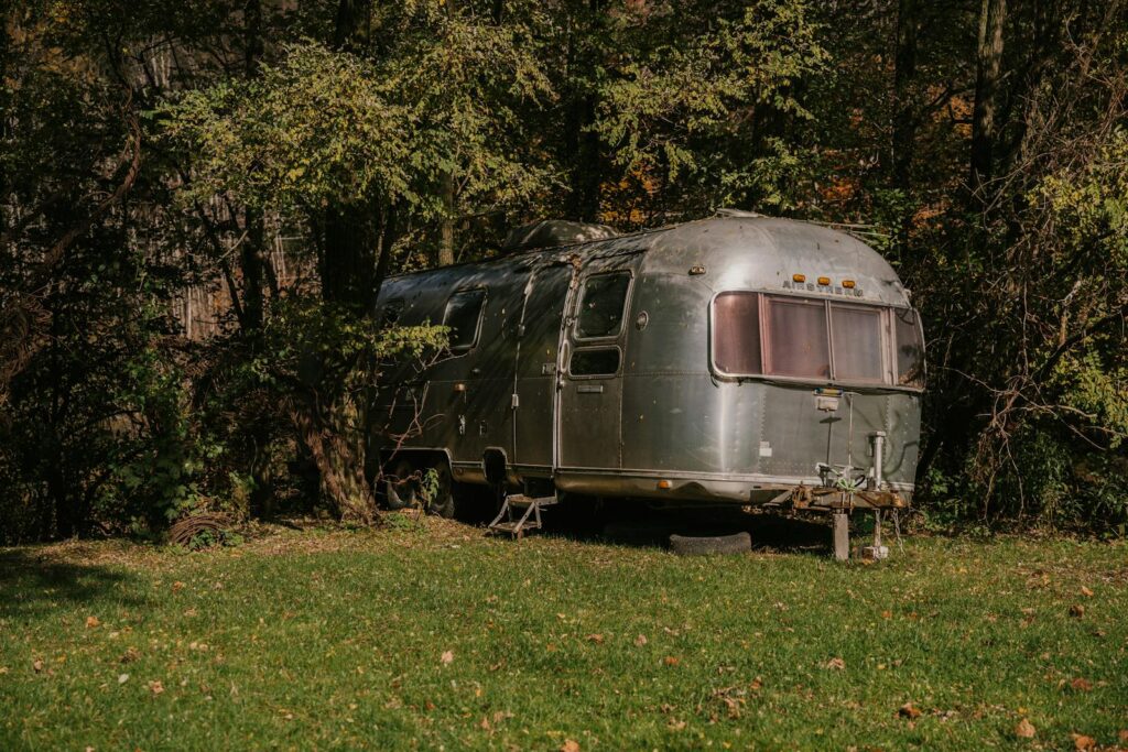 Old fashioned motor house stopped in green forest for people having rest at weekend