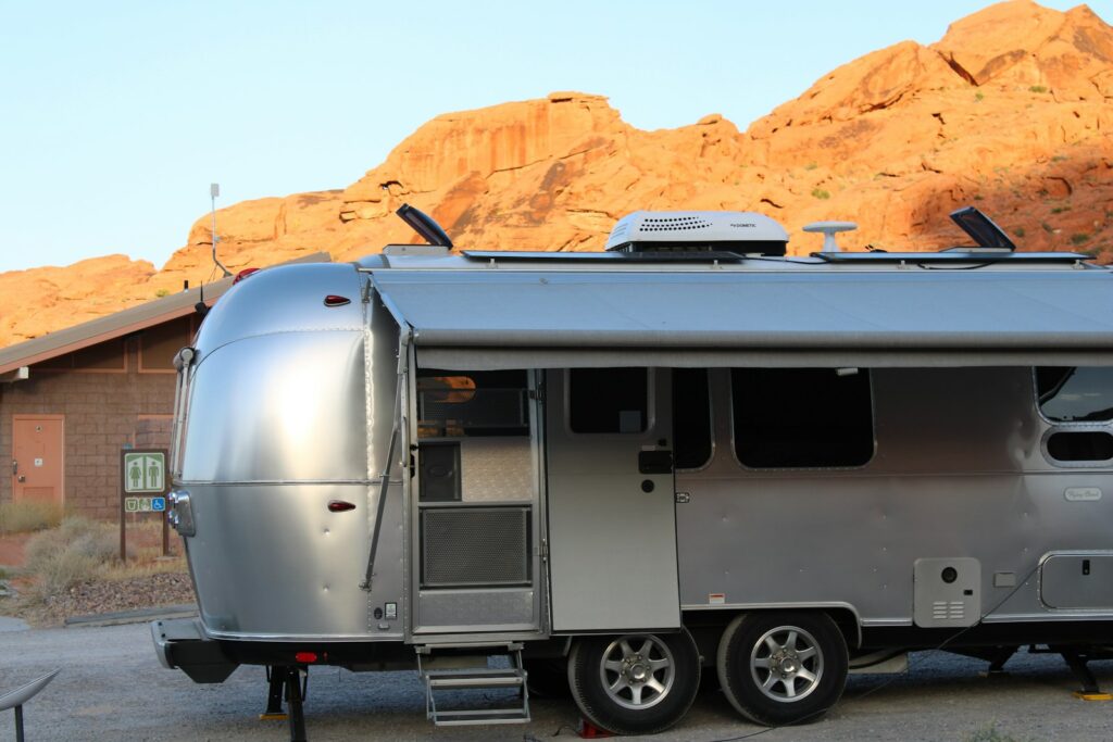 A silver trailer parked in front of a mountain