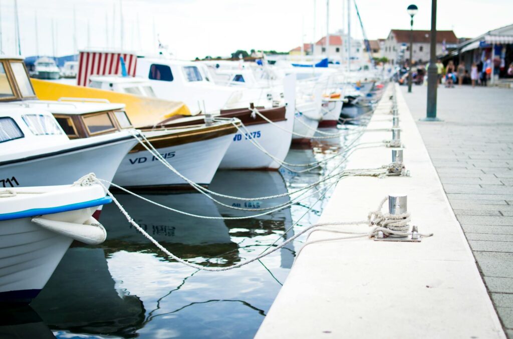 A collection of boats moored at a harbor pier on a clear day. Perfect for travel and maritime themes.