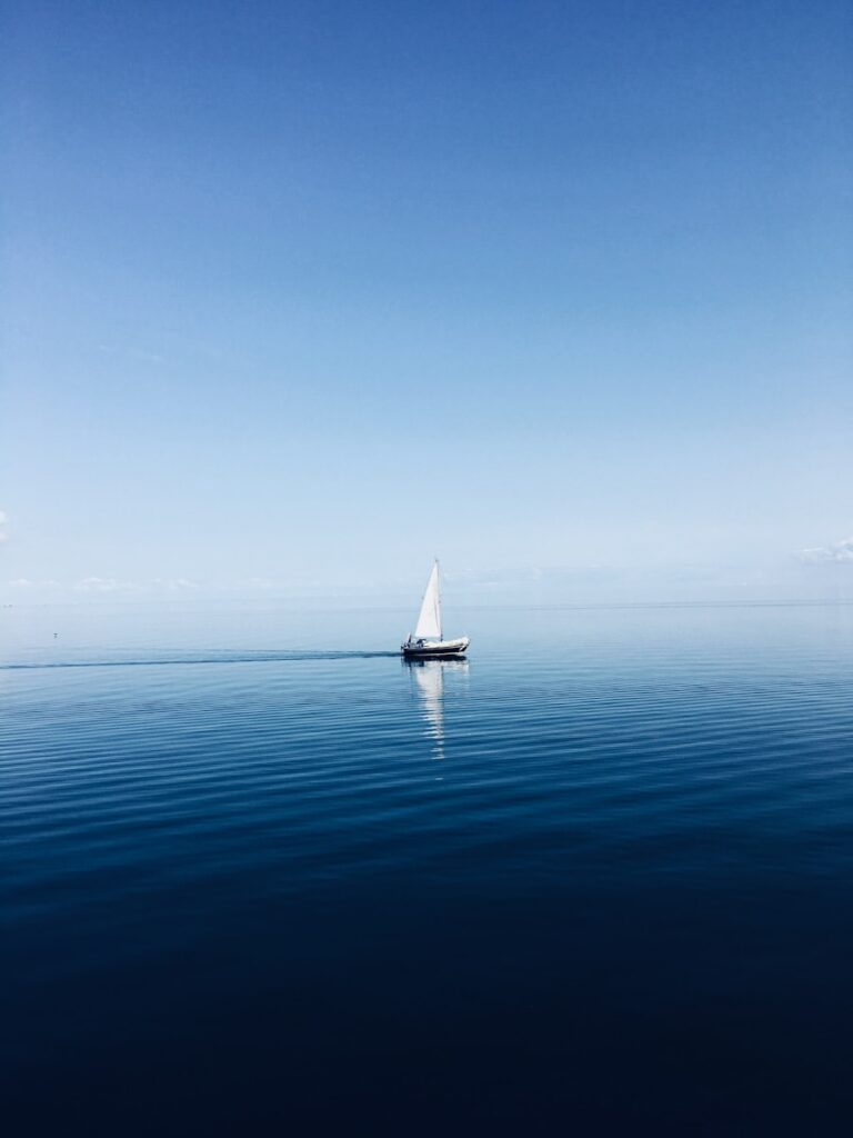 white sailboat at middle of ocean