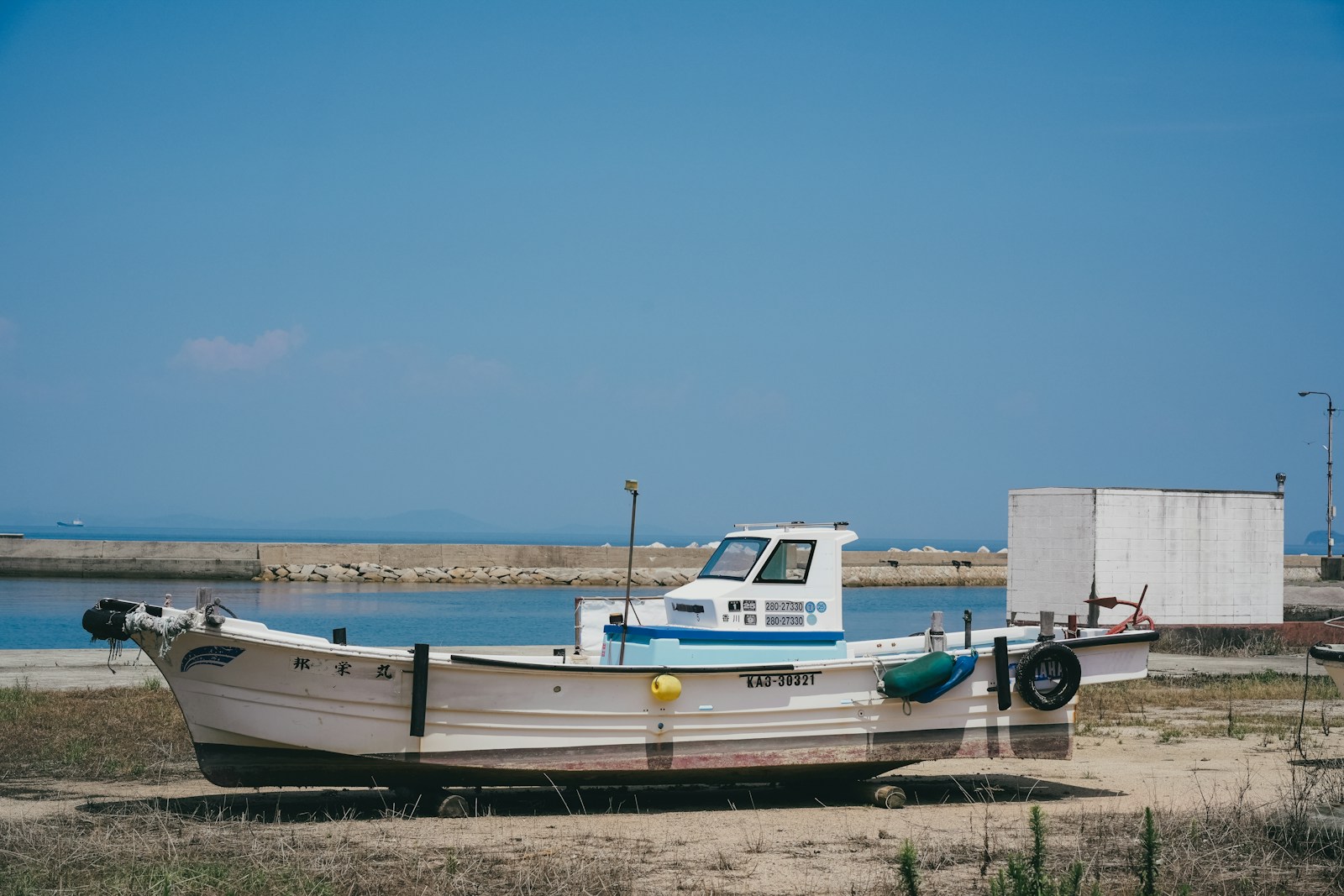 A small fishing boat rests on a sandy shore. Boat Trailer Transport: What to Check Before You Hit the Road