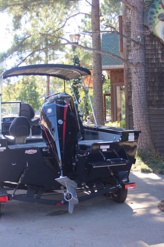 A black motorboat with a large outboard engine.