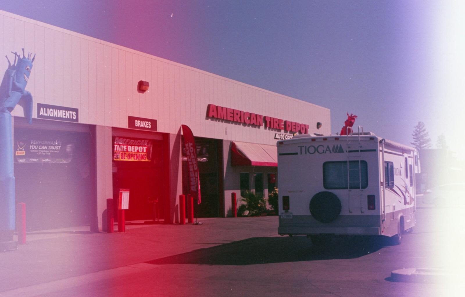 Photo by YoItsCapture RV parked outside an American Tire Depot building under clear skies.