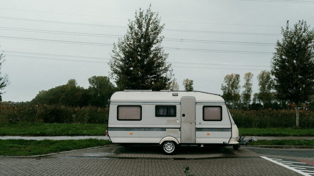 A vintage camper trailer parked in a serene outdoor setting with lush greenery.