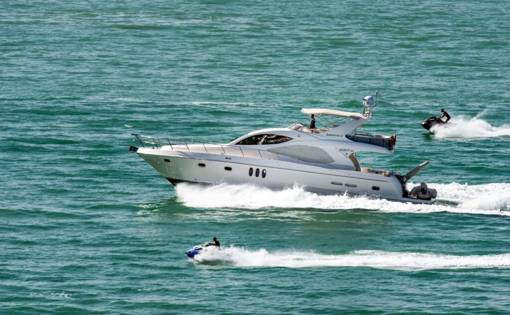A luxury yacht and jet skis cruising on the open sea, depicting speed and adventure.