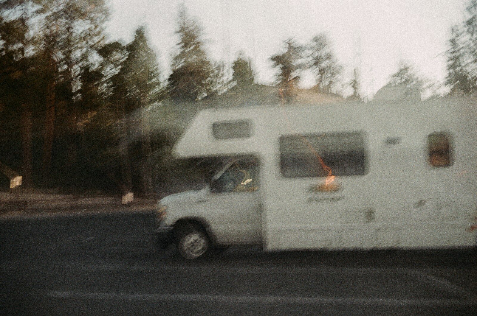 Photo by Roberto Shumski A white rv driving on a road.