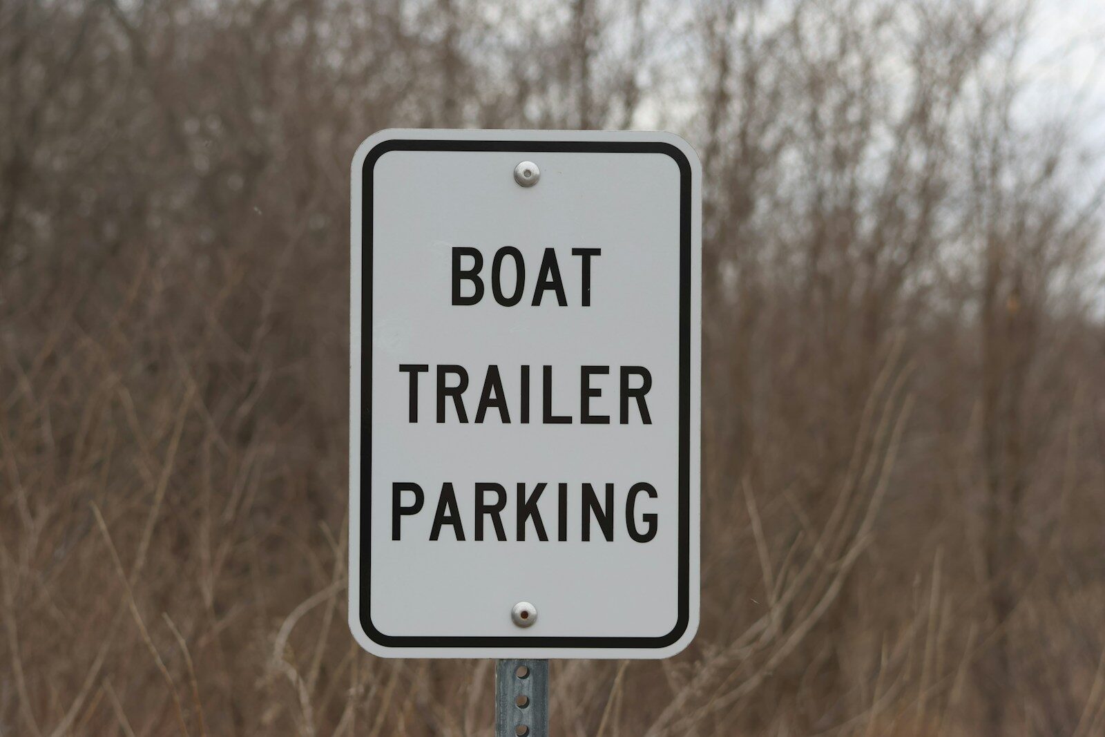 Boat trailer parking sign in front of dry brush