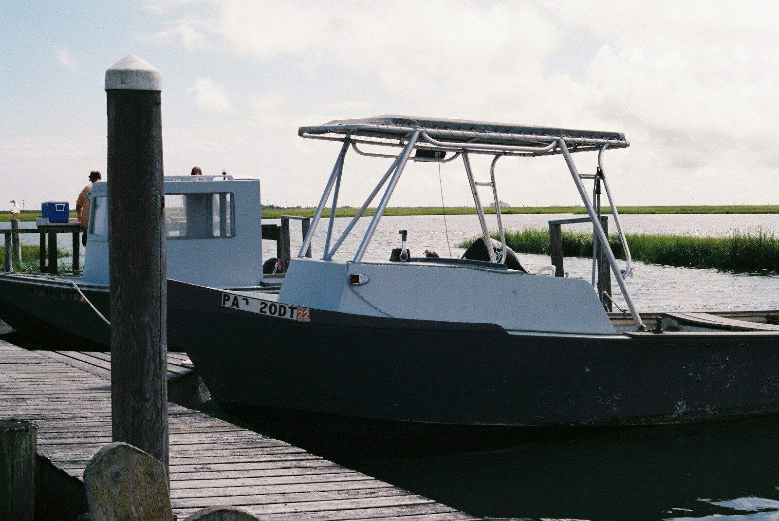 a boat docked at a pier with people on it