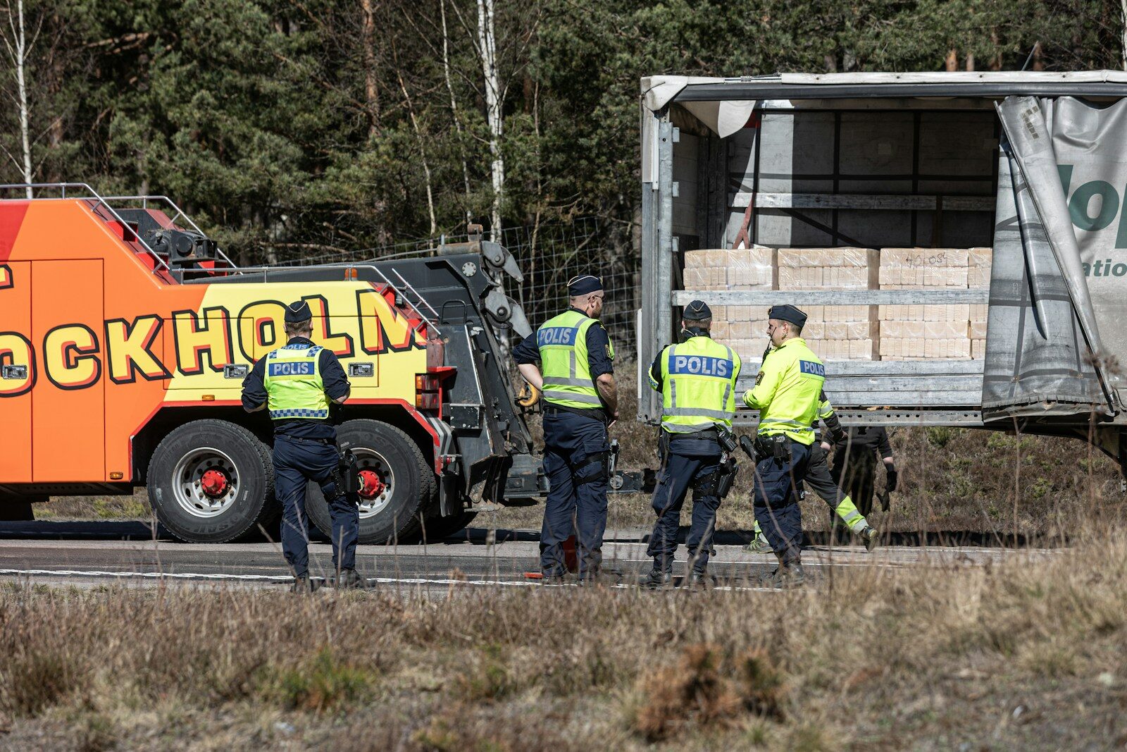Photo by Carl Tronders Police officers investigate a truck with a tow truck.