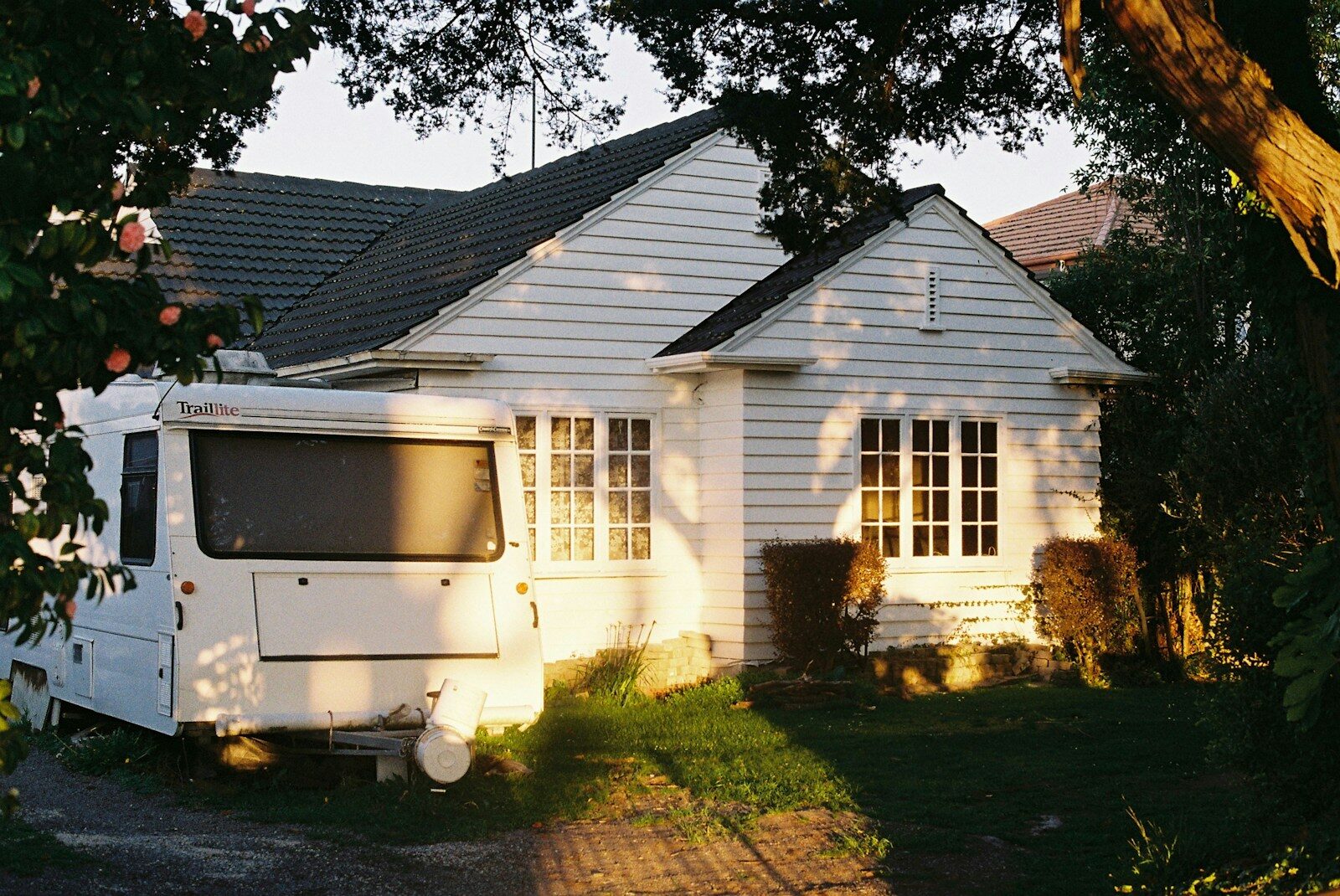 Photo by Oleg Yudin A white house with a white trailer parked in front of it
