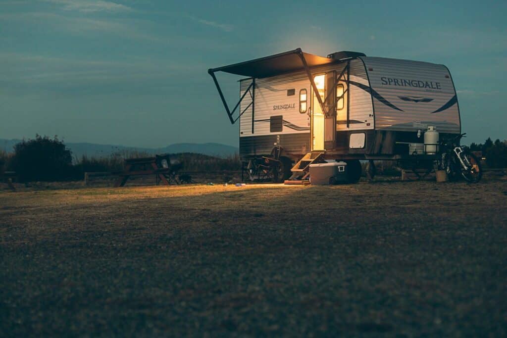 a small camper sits in a field at night