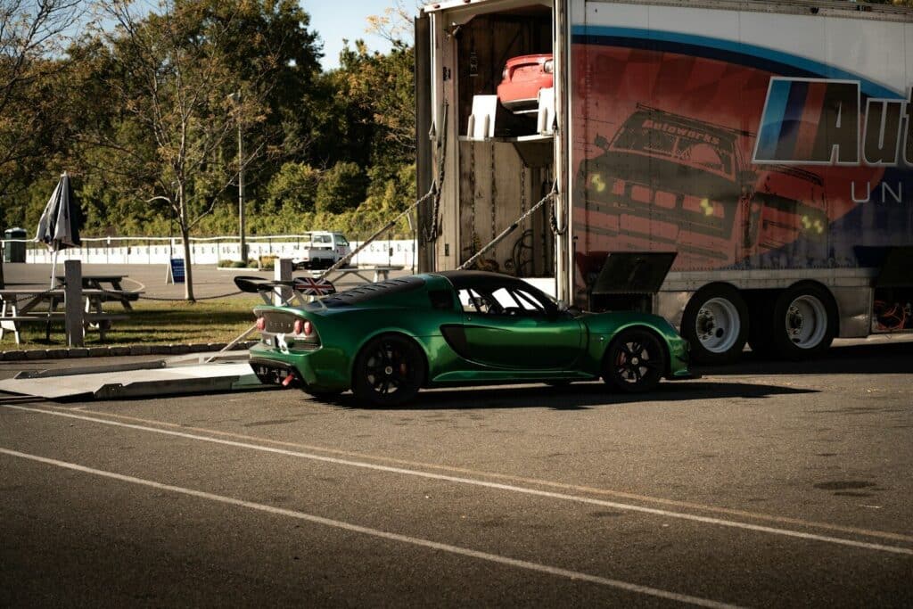 Green sports car being loaded into a trailer.
