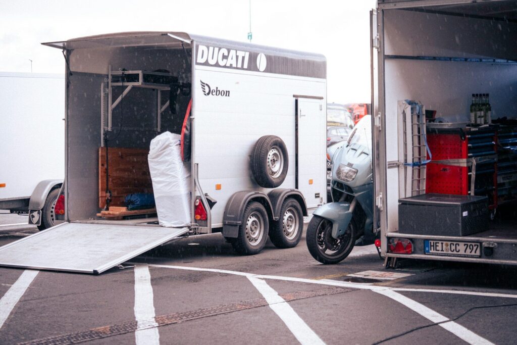 A ducati motorcycle is next to a trailer.