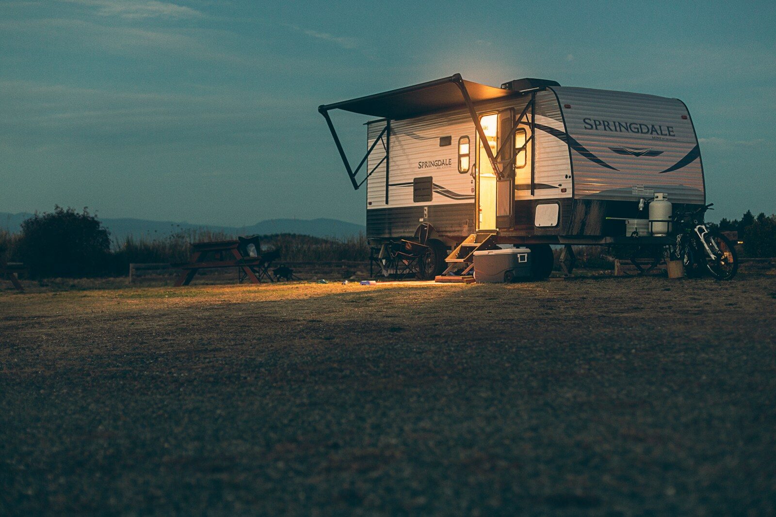 Photo by Devon MacKay a small camper sits in a field at night Top 8 RV Manufacturers: Our 2026 Expert Recommendations for Your Next Adventure