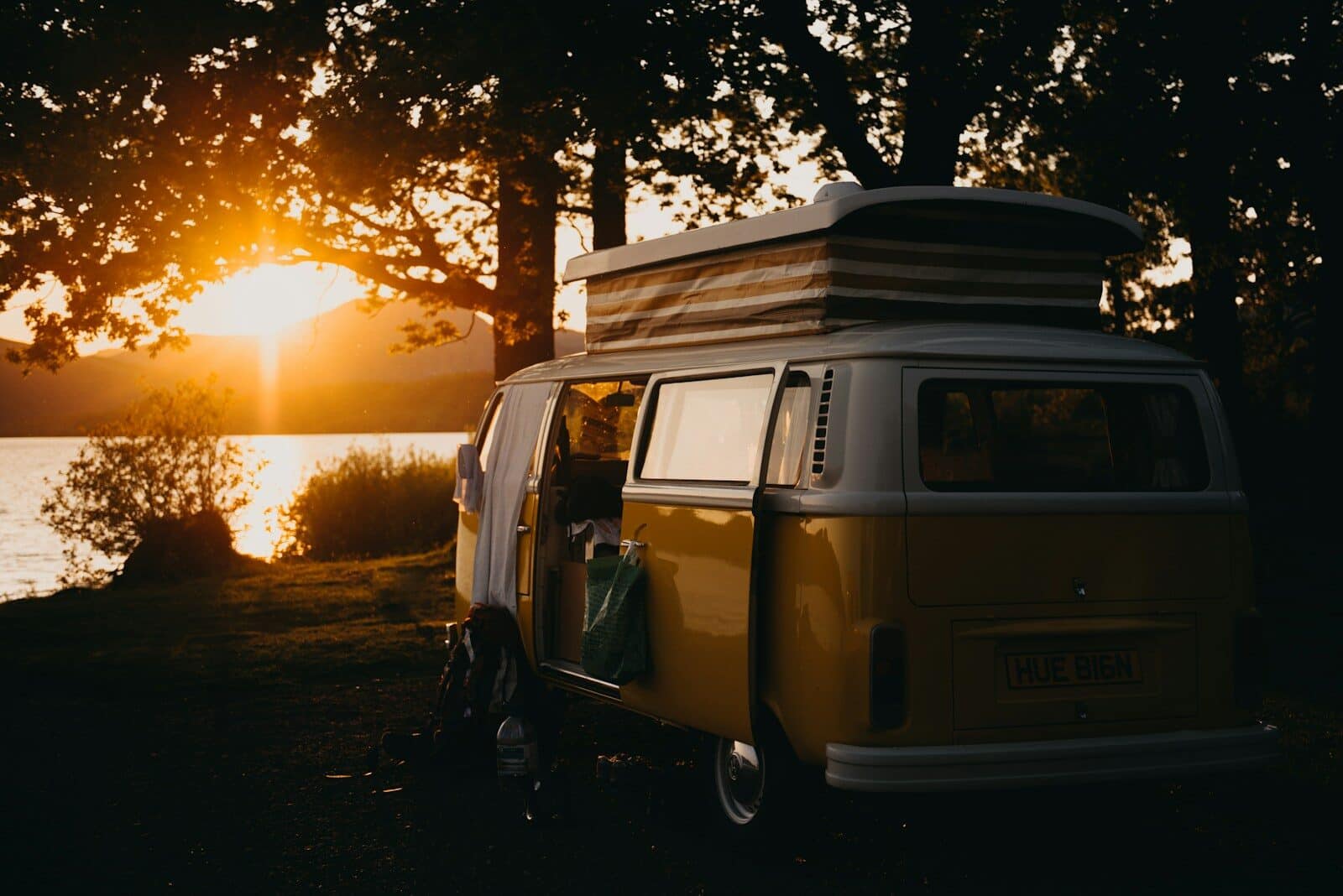 Photo by Kevin Schmid brown van under the tree during sunset Essential Camper Storage Ideas: Safely Transport Your Gear with Professional Help