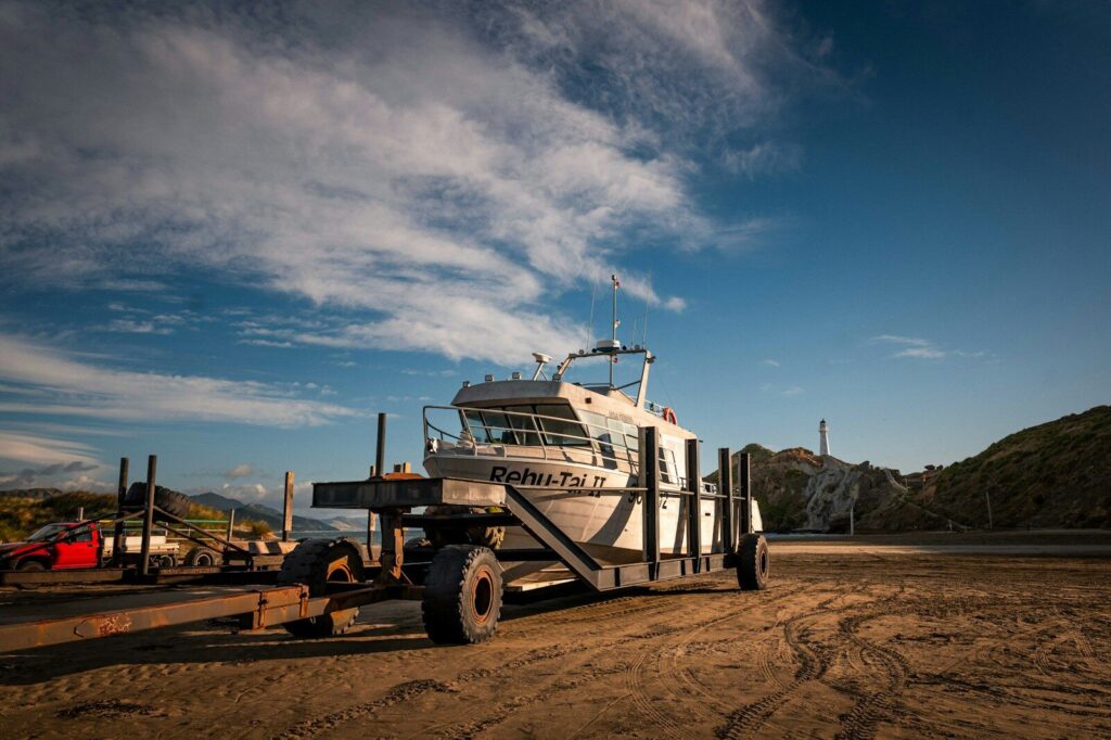 A boat on a trailer under a cloudy blue sky.