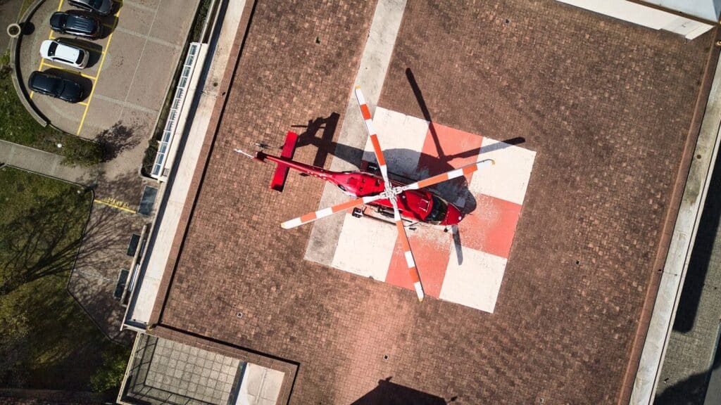 Red helicopter lands on a helipad